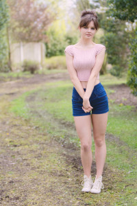 Pink handknit crop top worn with blue high waisted denim shorts