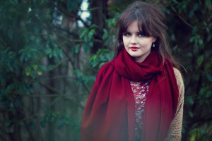 Rich red scarf photographed against leafy green background