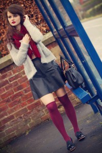 Brunette girl waiting at bus stop on rainy day