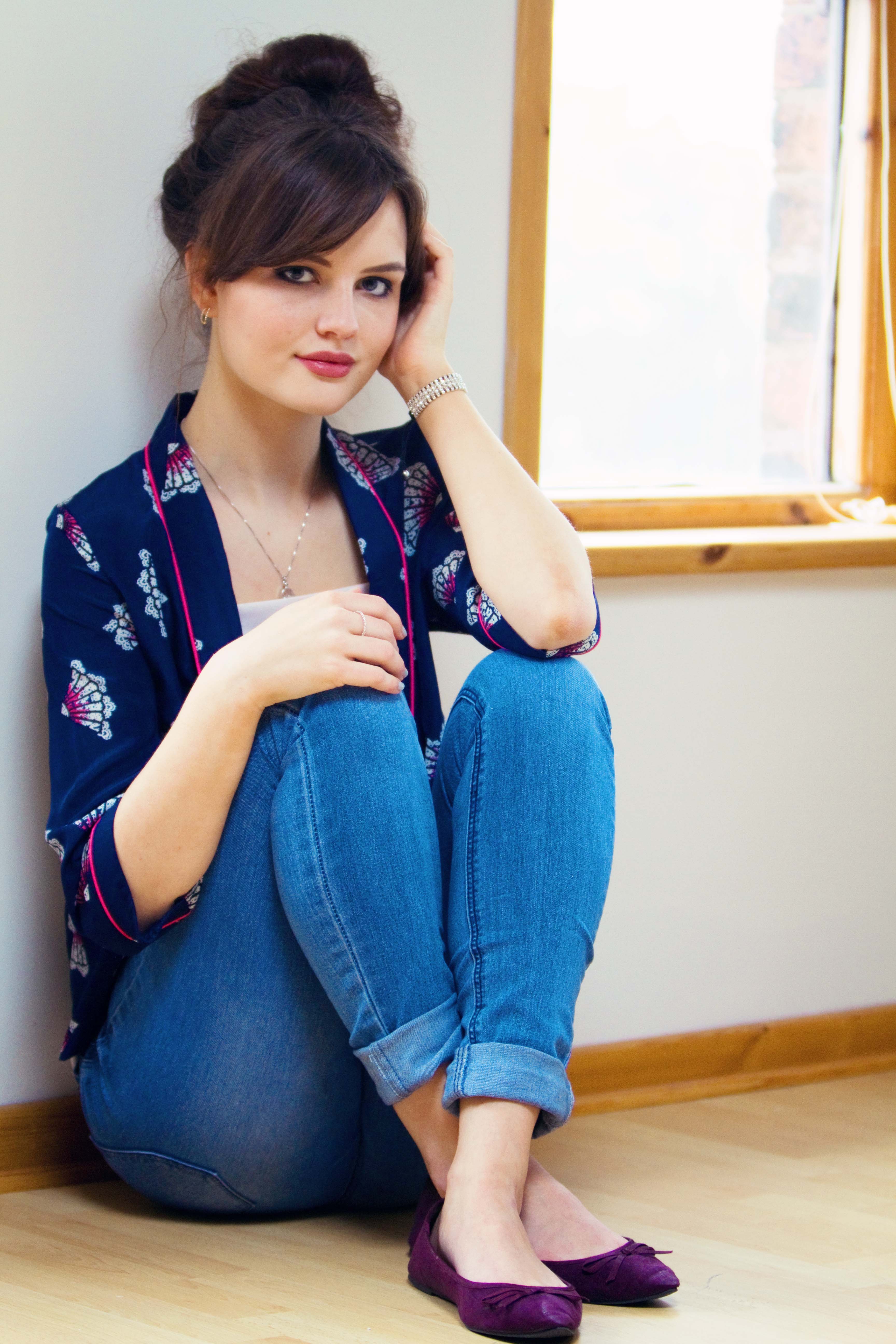 Brunette wearing Tollied Dolly jacket and blue cropped jeans