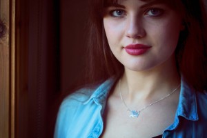 Brunette teen wearing name necklace and denim shirt