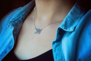 Name necklace worn with pale denim shirt