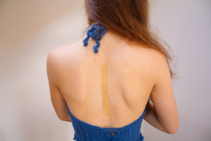 Girl wearing blue crochet halter and gold tattoo