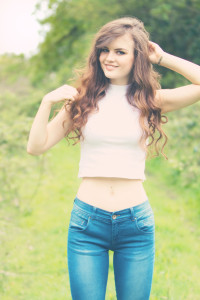 Smiling teen girl wearing jeans and white high neck cropped top