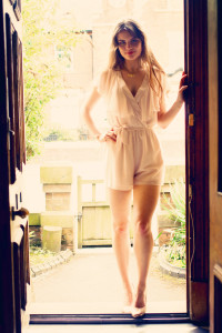 Teen photographed in doorway wearing cream playsuit