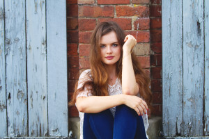UK teen blogger portrait taken in from of blue painted doors