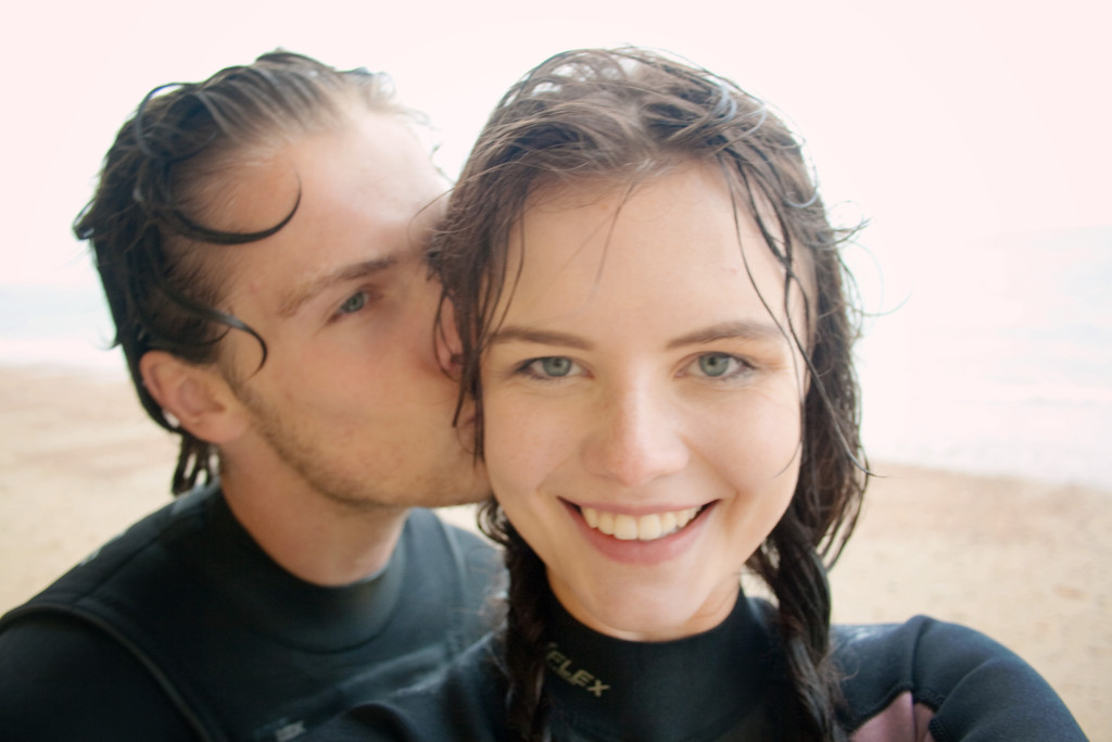 cute-young-couple-in-wetsuits