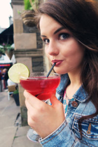 Teen girl drinking pink cocktail with straw