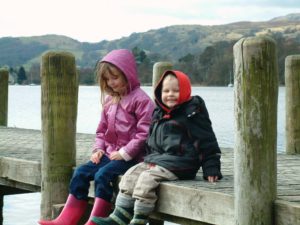 toddler boy and young child on lake jetty