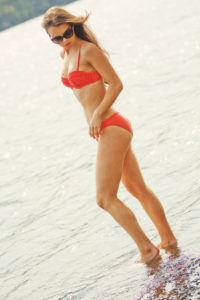 Teen girl wearing sunglasses and red Triangl bikini