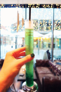 Cocktail served in test tube. Green cocktail. Iceless mojito cocktail