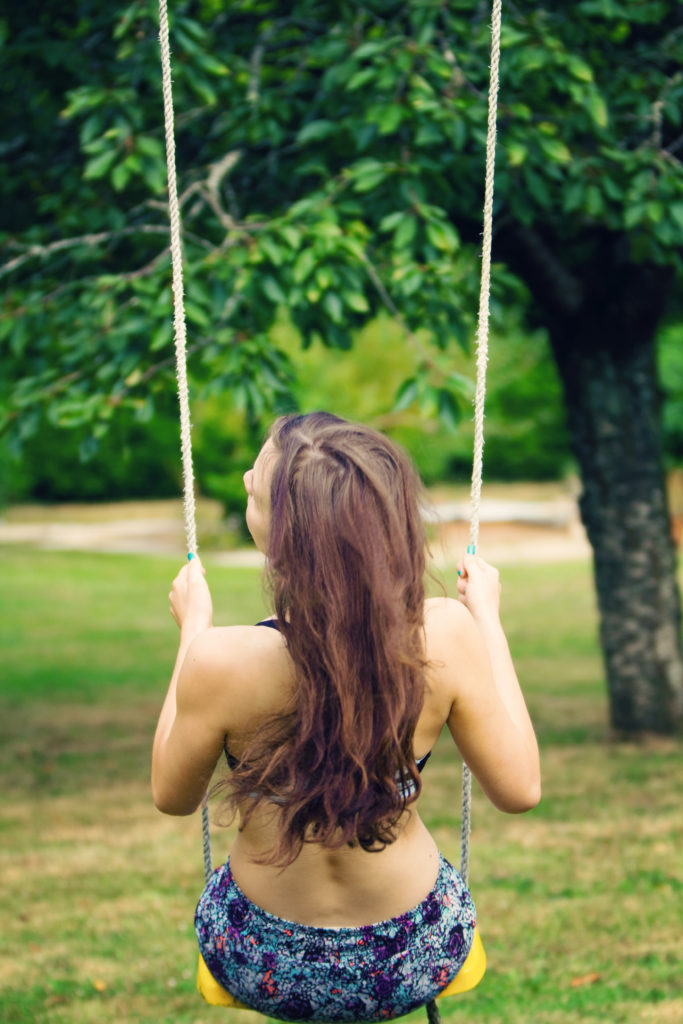 Teen girl on swing wearing bikini
