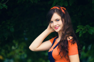 Brunette teen wearing dungaree outfit with orange bandana