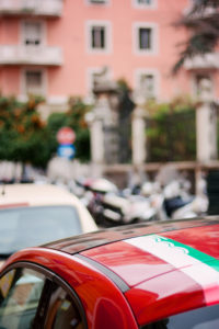 Green and white stripe on Red Fiat 500 car. Rome Italy.