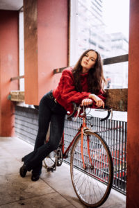 Young woman leaning on bike in Northern Quarter Manchester