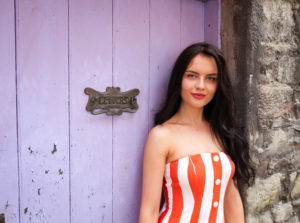 Female model wearing orange and white strapless dress