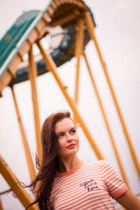 Girl standing in front of roller coaster in Blackpool