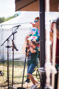 Young boy singing at summer festival